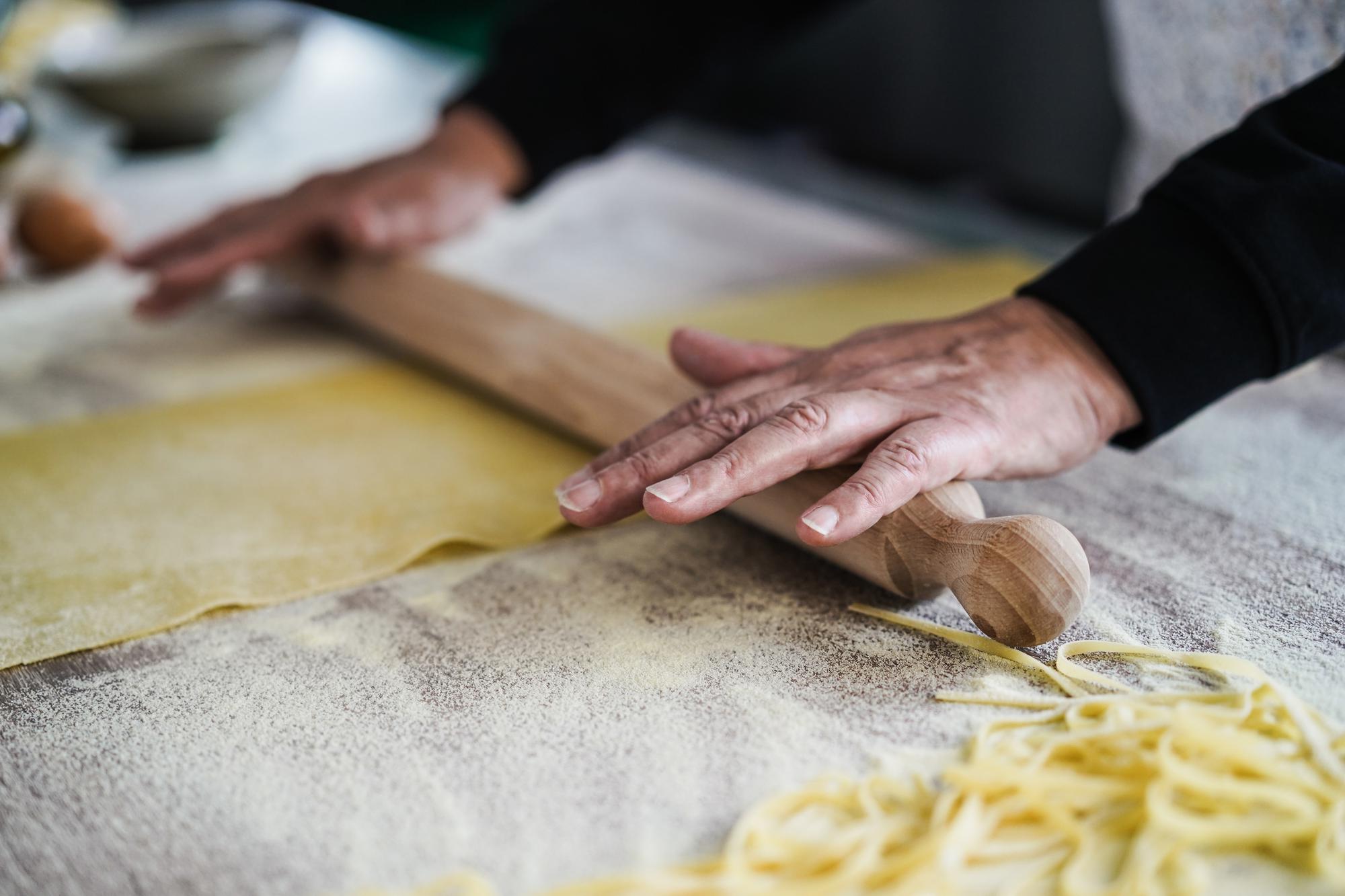 Close-up of hands folding fresh pasta